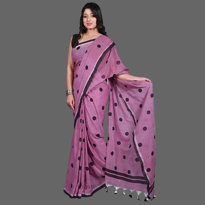 Woman wearing a purple saree with black polka dots on a white background