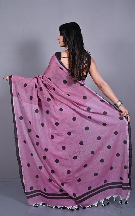 Woman wearing a purple saree with black polka dots on a white background